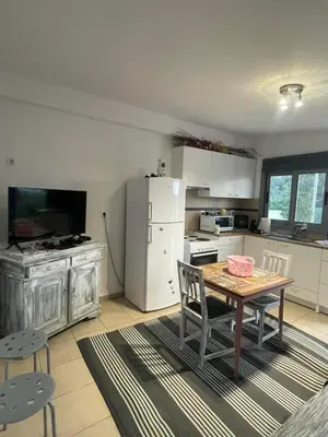 a kitchen with a table and a white refrigerator at Simple Stay Vari's House in Vari