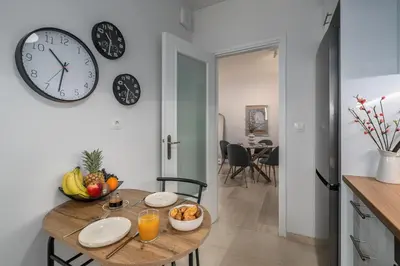 a dining room with a table and a clock on the wall at The rock view apartment in Athens