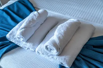 a pile of white towels sitting on a bed at The rock view apartment in Athens