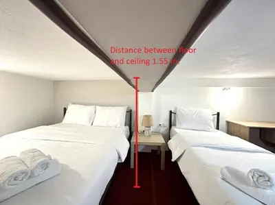 two beds with white sheets and towels on them in a room at Tide and Tonic spacious 1bd apartment with extra Loft Style Sleeping Area, Paleo Faliro in Athens