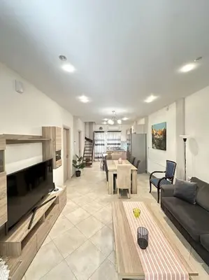 a living room with a couch and a table at Tide and Tonic spacious 1bd apartment with extra Loft Style Sleeping Area, Paleo Faliro in Athens