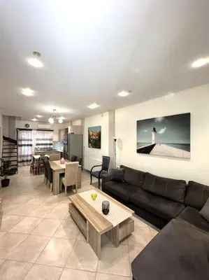 a living room with a couch and a table at Tide and Tonic spacious 1bd apartment with extra Loft Style Sleeping Area, Paleo Faliro in Athens