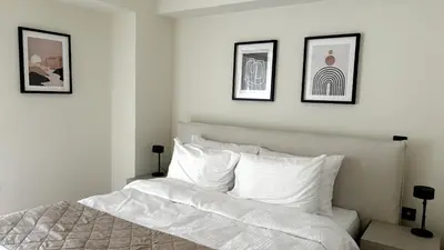 a bedroom with a white bed with three pictures on the wall at The White Marble - Spacious, 4BR, 2BA in Paleo Faliro in Athens