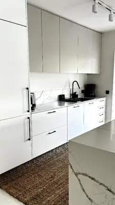 a white kitchen with white cabinets and a sink at The White Marble - Spacious, 4BR, 2BA in Paleo Faliro in Athens