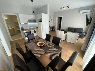 a dining room table and chairs in a living room at Ydrea Piraeus port apartment in Piraeus