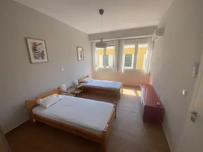 a room with two beds and a window at Ydrea Piraeus port apartment in Piraeus
