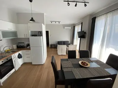 a kitchen and dining room with a table and a kitchen and a living room at Ydrea Piraeus port apartment in Piraeus