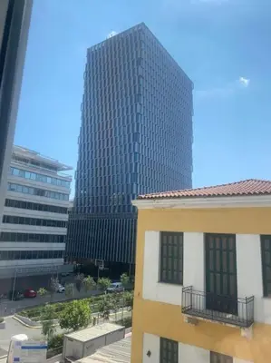 a tall building in the middle of a city at Ydrea Piraeus port apartment in Piraeus