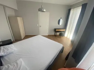 a bedroom with a white bed and a window at Ydrea Piraeus port apartment in Piraeus