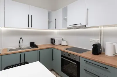 a kitchen with white cabinets and a sink at Phaedrus Living Zografou Azure Aura in Athens