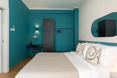 a bedroom with a large bed with blue walls at Phaedrus Living Zografou Azure Aura in Athens
