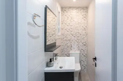 a white bathroom with a sink and a mirror at Phaedrus Living Zografou Azure Aura in Athens