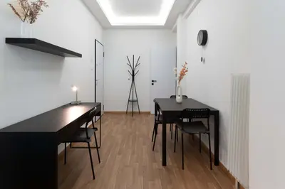 a dining room with a black table and chairs at Phaedrus Living Zografou Azure Aura in Athens