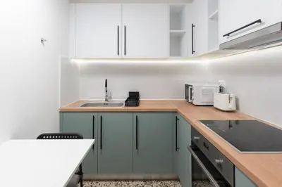 a kitchen with white cabinets and a sink at Phaedrus Living Zografou Azure Aura in Athens