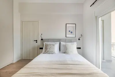 a bedroom with a large bed with white walls at Lovely 3BR Apartment in Pangrati by UPSTREET in Athens