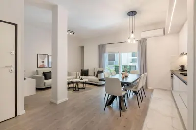 a dining room and living room with a table and chairs at Lovely 3BR Apartment in Pangrati by UPSTREET in Athens
