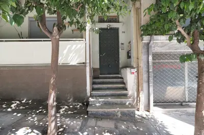 a building with stairs leading to a green door at Lovely 3BR Apartment in Pangrati by UPSTREET in Athens