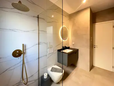 a bathroom with a toilet and a glass shower at NEW! Incredible 1BR Apt in Koukaki with AC in Athens