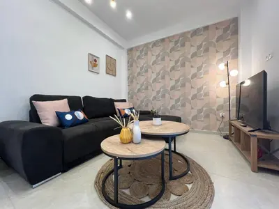 a living room with a black couch and two tables at NEW! Incredible 1BR Apt in Koukaki with AC in Athens