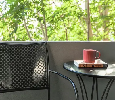 a red cup sitting on a table with a book at The Meta Stay - Rooftop Access Downtown Studio in Athens