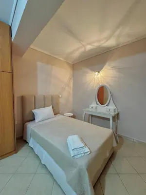 a bedroom with a bed with a mirror and a table at DOLCE VITA LUXURY APARTMENT Markopoulo in Markopoulo