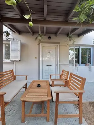 three wooden chairs and a table in a patio at DOLCE VITA LUXURY APARTMENT Markopoulo in Markopoulo