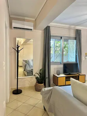 a living room with a tv and a mirror at DOLCE VITA LUXURY APARTMENT Markopoulo in Markopoulo