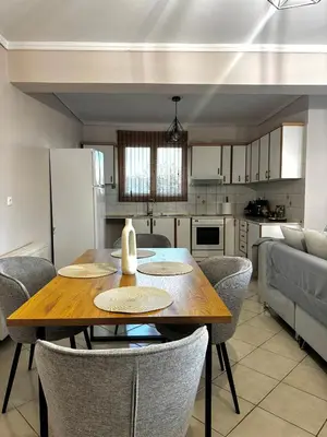 a kitchen and dining room with a wooden table and chairs at DOLCE VITA LUXURY APARTMENT Markopoulo in Markopoulo