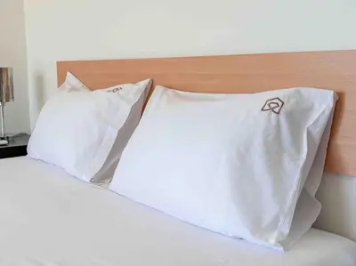 a bed with two white pillows on top of it at Light & Spacious Apartment near Glyfada Center in Athens