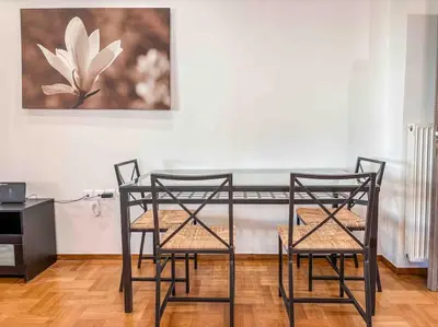 a dining room table with two chairs and a painting at Light & Spacious Apartment near Glyfada Center in Athens