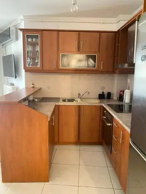 a kitchen with wooden cabinets and a sink at Cozy home in Piraeus