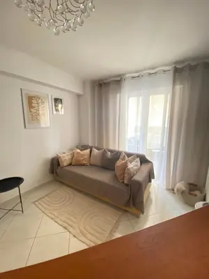 a couch in a living room with a chandelier at Cozy home in Piraeus