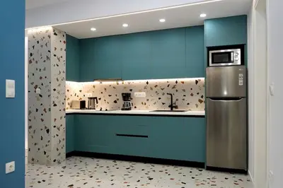 a kitchen with blue cabinets and a stainless steel refrigerator at Modern Style Suite VIPGreece in Athens