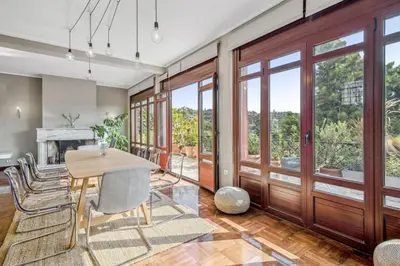 a dining room with a table and chairs and sliding glass doors at the Acropolis Noir Penthouse in Athens