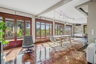 a dining room with a table and chairs and windows at the Acropolis Noir Penthouse in Athens