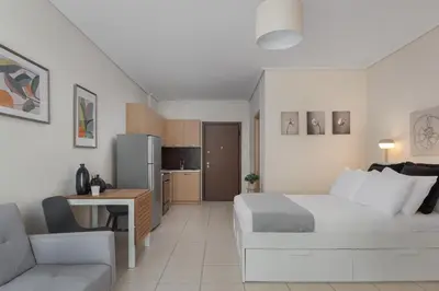 a bedroom with a bed and a couch and a kitchen at Athenian Comfort Apartments in Athens