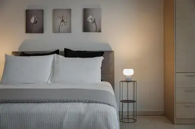 a bedroom with a bed and three pictures on the wall at Athenian Comfort Apartments in Athens