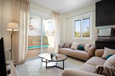a living room with a couch and a table at Helios Residence by A&D Properties in Porto Rafti