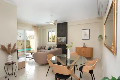 a living room with a glass table and chairs at Helios Residence by A&D Properties in Porto Rafti