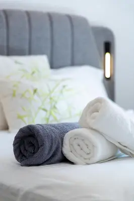 a pile of towels laying on a bed at Helios Residence by A&D Properties in Porto Rafti
