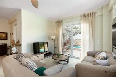a living room with two couches and a television at Helios Residence by A&D Properties in Porto Rafti