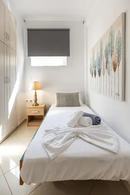 a white bedroom with a large bed with a window at Helios Residence by A&D Properties in Porto Rafti