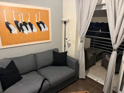 a living room with a gray couch and a window at Athens view penthouse with private parking in Athens