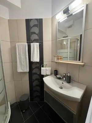 a bathroom with a sink and a mirror and towels at Athens view penthouse with private parking in Athens