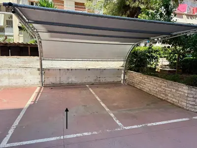 awning over a parking lot with a black arrow pointing up at Athens view penthouse with private parking in Athens