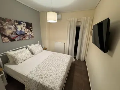 a bedroom with a bed and a tv on a wall at Athens view penthouse with private parking in Athens