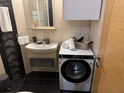 a small bathroom with a washing machine and a sink at Athens view penthouse with private parking in Athens