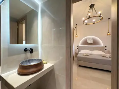 a bathroom with a sink and a bedroom at A modern temple of Athena 1 & 2 in Athens