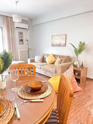 a living room with a table and a couch at Sea the City - Chic 2-BDR Escape with Spacious Living in Athens