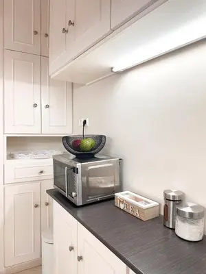 a kitchen with a microwave and a bowl on a counter at Sea the City - Chic 2-BDR Escape with Spacious Living in Athens